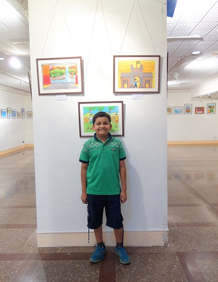 Tanmay Karve with his painting in the background at Khula Aasmaan -
Children's Art Exhibition - Edition I
presented by Indiaart Gallery