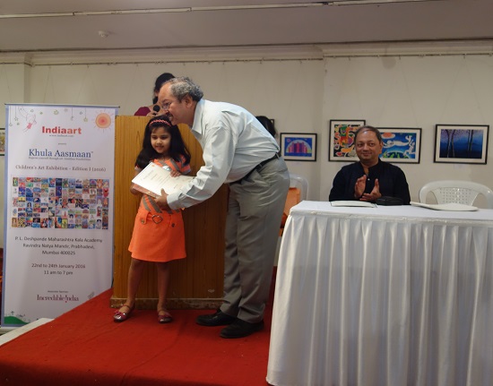 Prof. Yashwant Pitkar giving away
the certificate to a child artist
with Milind Sathe in the background