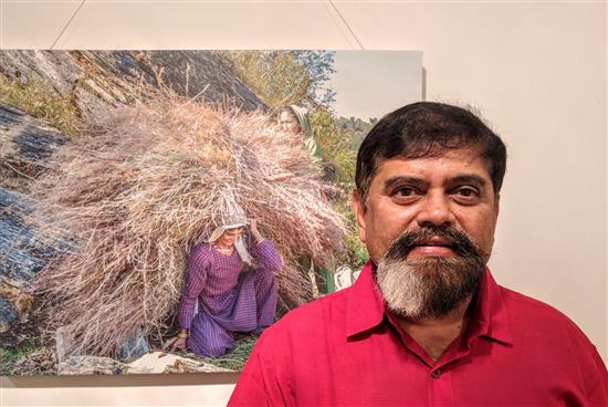 Achyut Godbole with one of the pictures from Milind Vishwas Sathe's show Call of the Hills at Jehangir Art Gallery, Mumbai