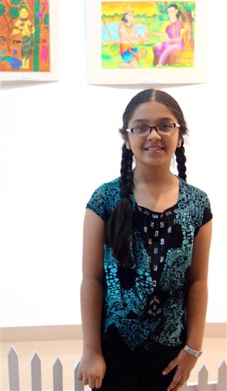 Child artist with her painting in the background