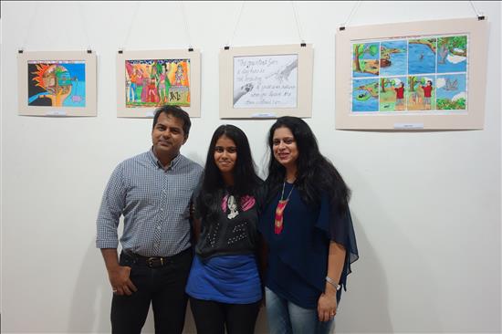 Yound artist flanked by parents with painting in the background