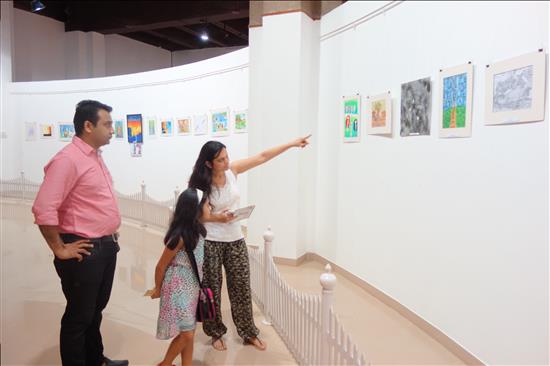 Parents keenly looking at the paintings on display