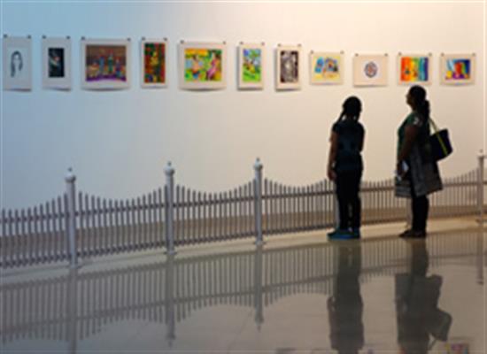 Participating child artist with parent looking at the display