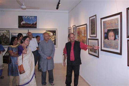 Milind Sathe talks about his pictures as Dr. Jayant Narlikar, Dr. K. Ganesh and Smt. Mangala Narlikar look at the show