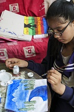 Deciding on what else she needs to do in this painting