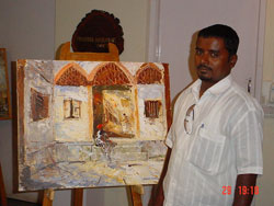 Artist Dinkar Jadhav with his paintings