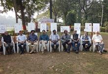 Group photo of cartoonists with their cartoons as a tribute to R. K. Laxman