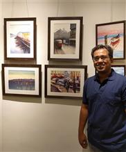 Ivan Gomes with his paintings at the second edition of Emerging Artists Show at Indiaart Gallery, Pune